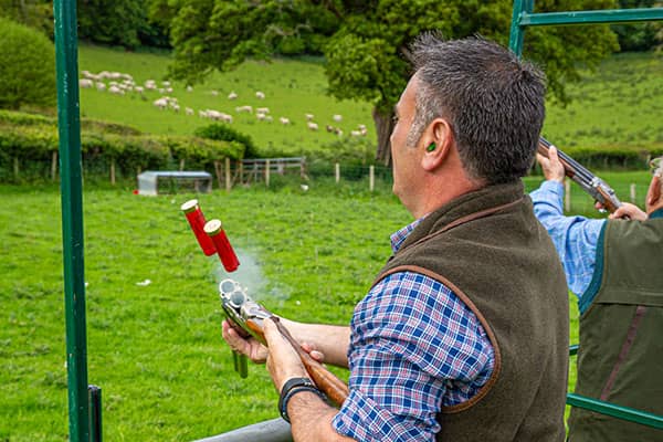 Firing shotgun at clay pigeon event